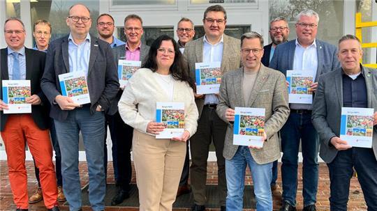 Frisch aus der Druckerei: Landrat Kai Seefried (vorn Mitte) und die Bürgermeister aus dem Landkreis Stade präsentieren die neue Infobroschüre.