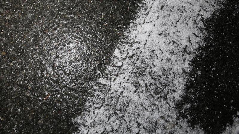 Frische Reifenspuren eines Winterreifens auf spiegelglatter Straße zeigen die winterlichen Straßenverhältnisse im Harz.