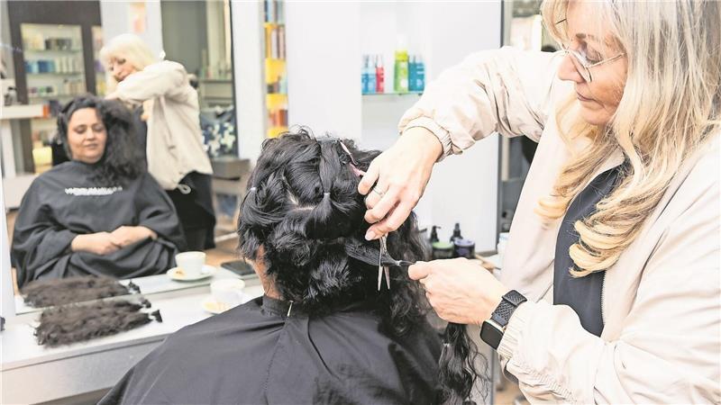 Friseurin Stefanie Merle vom Friseursalon van Ruiten in Bad Oldesloe schneidet ihrer Kundin Saba Siamis.