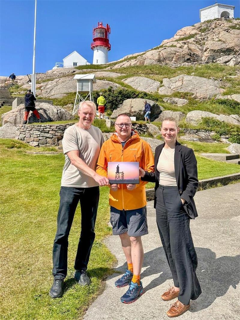 Frøya and Nils Olaf vom Lindesnes Fyrmuseum (Leuchtturm-Museum) in Norwegen freuen sich über den Besuch von Leuchtturm-Fan Thomas Krey (Mitte). Der hat als Geschenk ein Motiv vom Obereversand in Dorum-Neufeld dabei. 