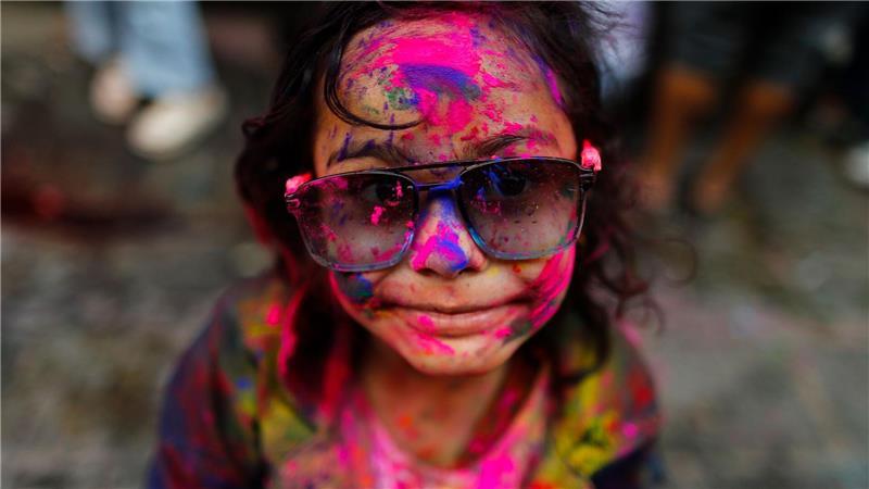 Frühlingsfest Holi in Nepal: Ein Mädchen mit gefärbtem Gesicht nimmt an den Feierlichkeiten teil.