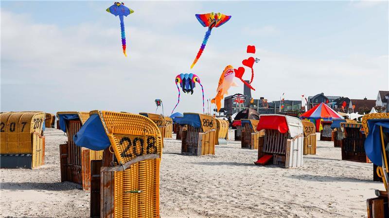 Frühlingstemperaturen - Großdrachen fliegen über dem Strand in Laboe. 