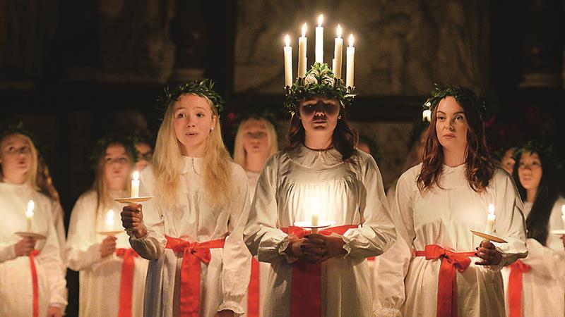 Fünf Kerzen als Kopfschmuck, daran ist die schwedische Lichterkönigin Lucia zu erkennen.