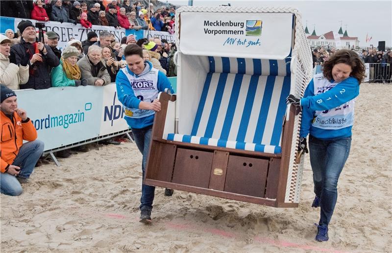 Für Danica Galla und Sonja Schelp ging es am Wochenende darum, einen 60 Kilogramm schweren Strandkorb möglichst schnell über den Sand zu tragen. Foto: Stefan Sauer/ dpa