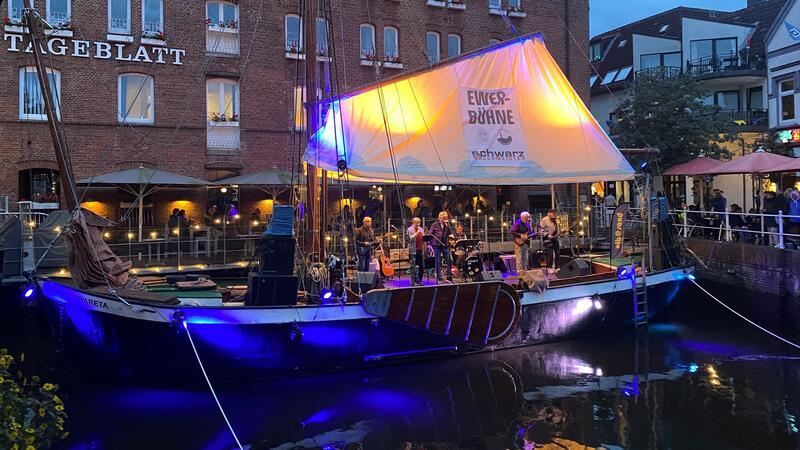 Premiere für das dritte große Fest in der Buxtehuder Altstadt Eine Band spielt auf der überdachten Bühne vom Ewer Margareta, der bereits für das Altstadtfest gedreht wurde und quer zum Fleth vor der alten Mühle liegt