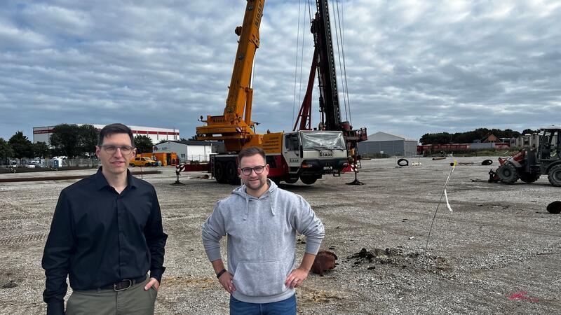Für die Gründung müssen die Pfähle 18 Meter tief in den Boden: Steffen Pape (links) und Timo Metje stehen vor dem Bohrer.
