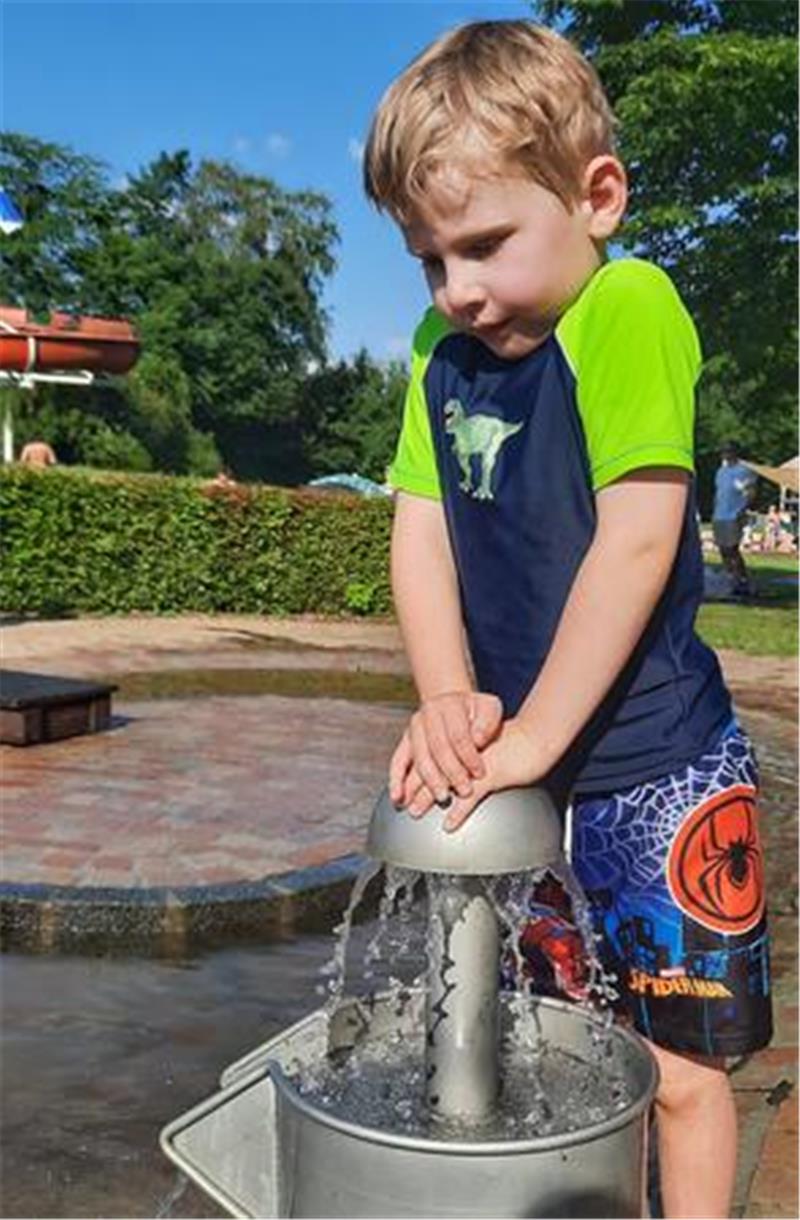 Für die Kleinsten gibt es nicht nur ein Babybecken mit blauem Folienboden, sondern auch einen Wasserspielplatz mit ganz vielen natürlichen Planschmöglichkeiten. Max (5) pumpt hier fleißig Wasser ins Becken.