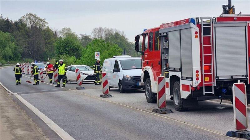 Feuerwehrleute reinigen die Fahrbahn nach einem Unfall auf der Ostebrücke in Hemmoor.
