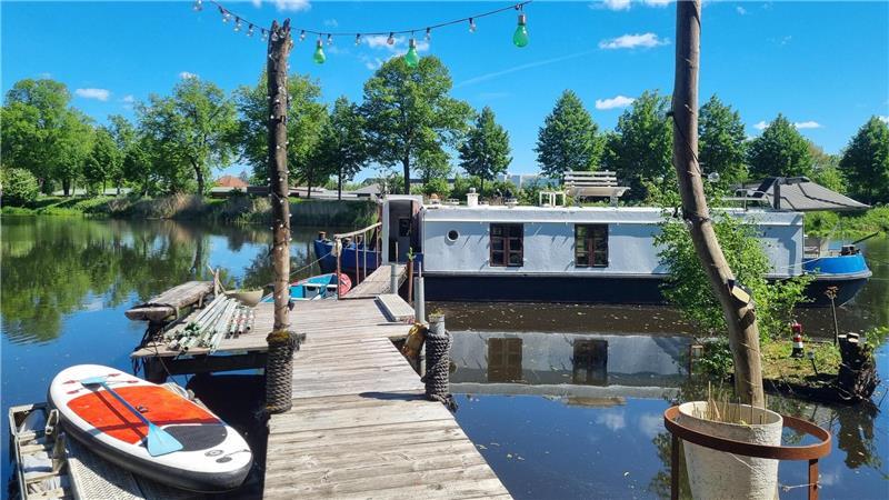 Ungewöhnlich übernachten: So schläft es sich auf einem Stader Hausboot Für sonnige Tage liegen am Steg ein SUP-Board und ein Elektromotorboot bereit.