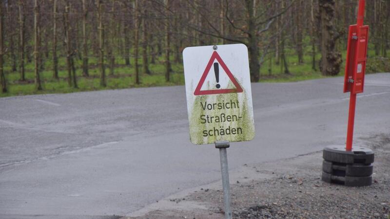 Für von der K39 kommende Autos weist ein Schild auf die Straßenschäden an der Wellenstraße hin.