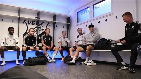 Fußballtrainer Björnn Stobbe (rechts) bespricht in der neuen Kabine das anstehende Training mit seinen Spielern.