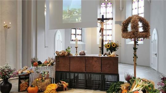 Gaben schmücken den Kirchenaltar zum Erntedankfest.