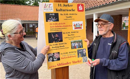Gabi Frieß und Herbert Scharf von Lust auf Kultur hängen Plakate für die Kulturwoche auf.