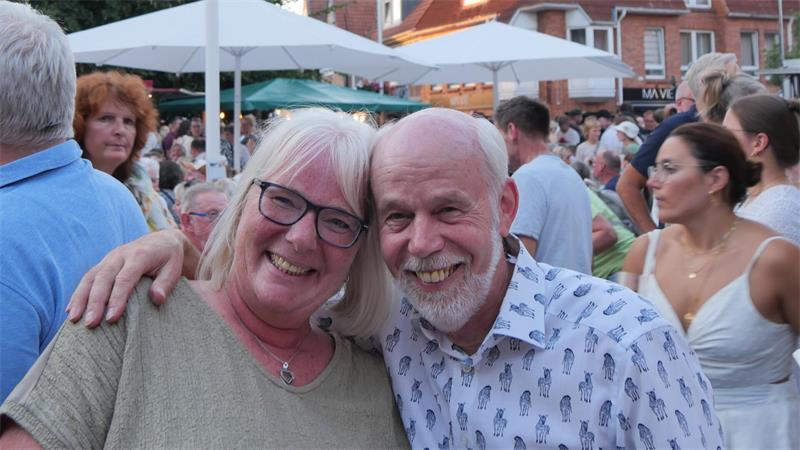 Gaby und Willi aus Moisburg genießen mit einer größeren Gruppe von Freundinnen und Freunden den Eröffnungsabend des Weinfestes unter dem Fahnendach auf dem Petriplatz.