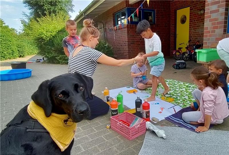 Geduldig wartet der Labrador Retriever Ciwi, während die Moorwichtel-Kinder mit Lisann Bukowski ein Bild malen. Fotos: Lohmann