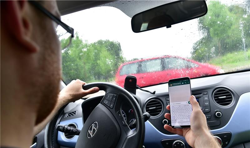 Gefährliche Ablenkung: Der Autofahrer hält das Smartphone in der Hand, sein Blick geht nach unten – da werden andere Verkehrsteilnehmer schnell übersehen. Foto: Schunk