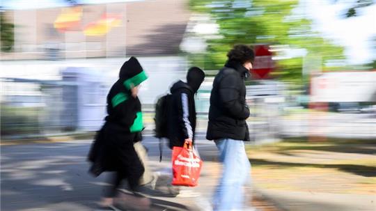 Geflüchtete gehen einer Landesaufnahmebehörde. Von Januar bis November 2023 haben in Deutschland rund 305.000 Menschen erstmals einen Asylantrag gestellt.