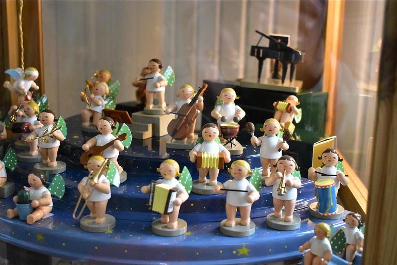 Engel als Mini-Figuren von Wendt und Kühn spielen in einem Orchester in einer Vitrine.