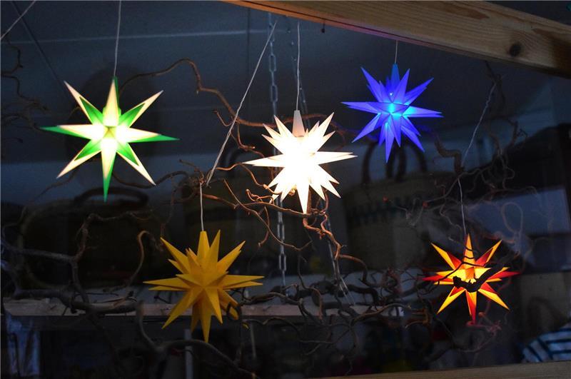 Herrnhuter Sterne leuchten über einem Verkaufstresen.