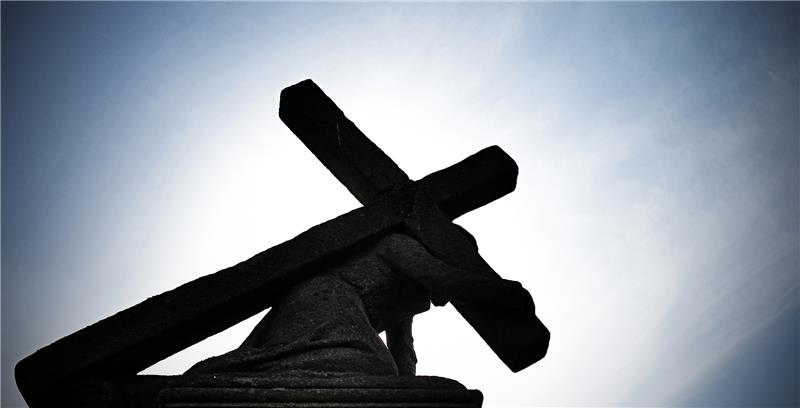 Sexualisierte Gewalt in Katholischer Kirche: Erzbistum Hamburg startet Betroffenenrat Gegen die Sonne zeichnet sich eine Jesusstatue unter dem Kreuz ab. Foto: Nicolas Armer/dpa