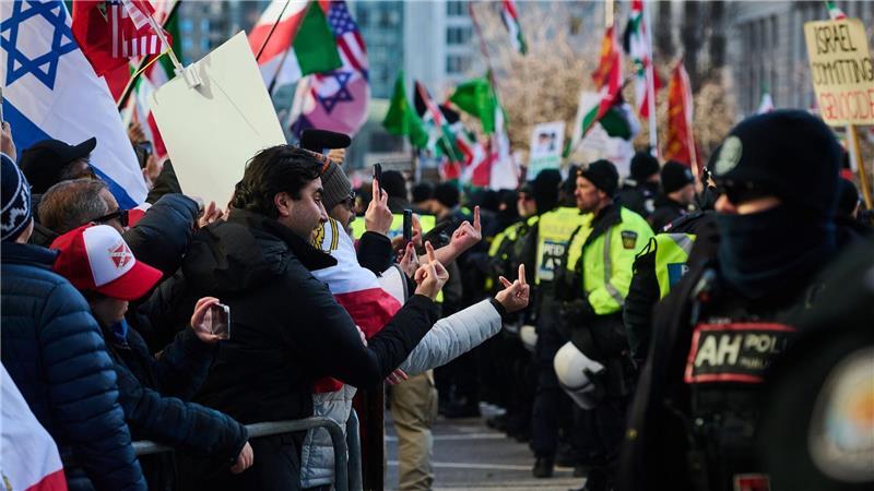 Gegendemonstranten reagieren auf vorbeiziehende Demonstranten in Toronto.