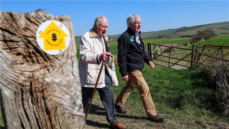 Gekleidet in Anzug und braunen Schuhen, wanderte der König gut zwei Kilometer an der Küste entlang.