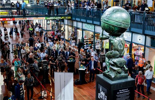 Geladene Gäste betrachten im Mai nach ihrer Enthüllung die restaurierte Atlas-Skulptur im Hauptbahnhof. Nun soll sie wieder auf dem Dach des Bahnhofs installiert werden. Foto: Axel Heimken/dpa