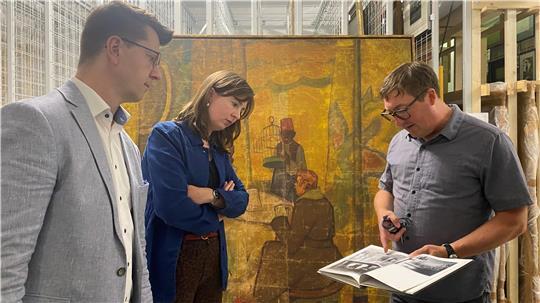 Gemälde-Übergabe im Depot: Museumsleiter Dr. Sebastian Möllers mit Egon Pankow (Fielmann-Niederlassung Stade) und Dr. Constanze Köster (Fielmann Kunstförderung) vor dem Werk von Theodor Herrmann.