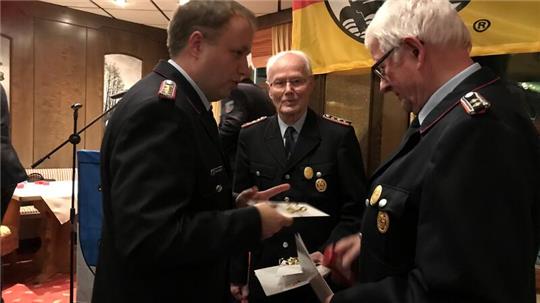 Gemeindebrandmeister Sven Nemitz überreichte Jürgen Schütt und Reinhard Schult (von links) die Goldene Ehrennadel für 60 Jahre Mitgliedschaft.