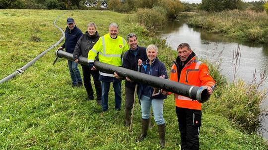 Gemeinsam für Hochwasser- und Naturschutz: Hans-Jürgen Bremer, Wilhelm Meyer, Rolf Scheibel, Michael Stöber, Gabriele Stiller und Helmut Meyer halten symbolisch ein Rohr für die Sandentnahme an der Aue in Horneburg in Händen (von links).