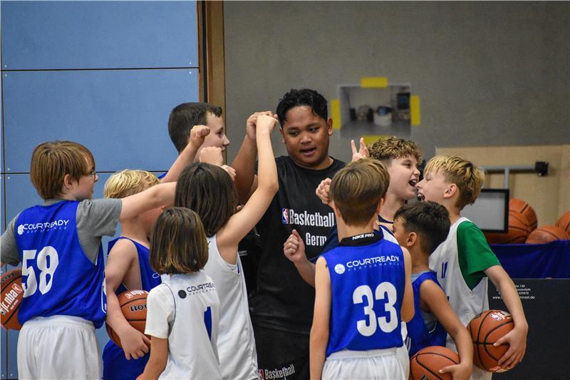 NBA-Camp in Stade: Junge Basketballer lernen von den Profis Einge Trainingsgruppe und ihr Trainer haben Spaß, geben sich die Faust und motivieren sich.