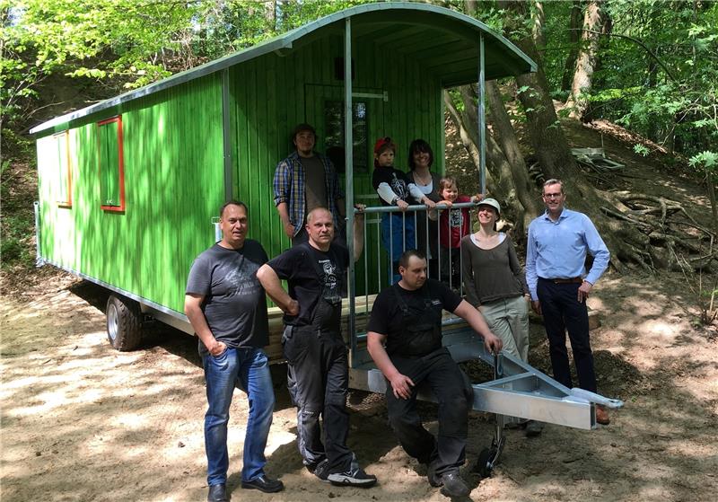 Gemeinsam haben Eltern, Erzieher, Kinder und Rathausvertreter den neuen grünen Bauwagen in den Waldkindergarten geschafft. Foto Herwede