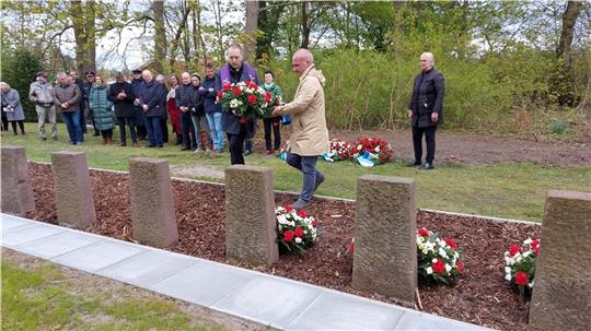 Gemeinsam mit Pastor Krystof Szydelko legten die stellvertretende Bürgermeisterin Daniela Oswald und der stellvertretende Ratsvorsitzende Kai Köser Kränze auf den Kriegsgräbern nieder. Foto: Hansestadt Stade