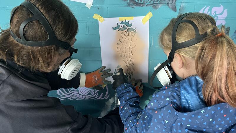 Kinder verschönern das Freibad Hollern-Twielenfleth mit Graffiti Gemeinsam mit dem Hamburger Künstlerduo CAROLÏN&PHILIPP bringen die Kinder ihre Motive an die Schwimmbadwand.