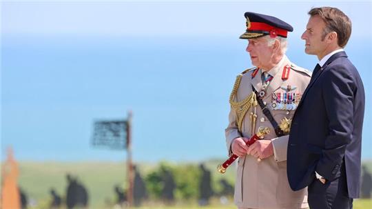 Gemeinsam stehen der britische König Charles III. und der französische Präsident Emmanuel Macron an der Atlantikküste in der Normandie. Am 6. Juni 1944 landeten hier die Soldaten der Alliierten.