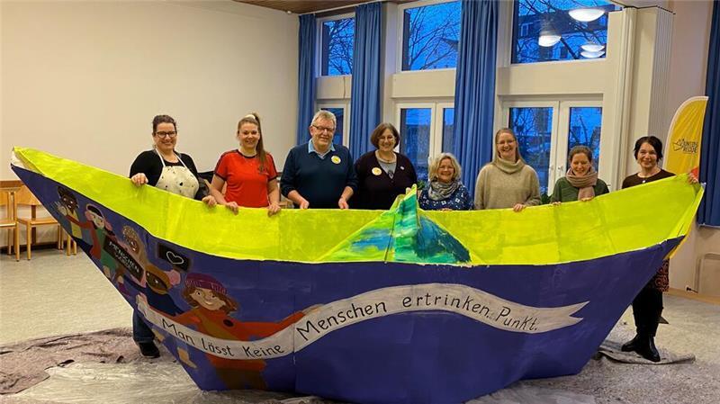 XXL-Schiff: Buxtehude sendet eine klare Botschaft nach Brüssel Gemeinsames Zeichen für mehr Solidarität mit Menschen auf der Flucht: Projektbeteiligte um die Inititiatoren Michael und Anja Stukenbrock (3. und 4. von links) mit der fast vollendeten Bo(o)tschaft für Brüssel.