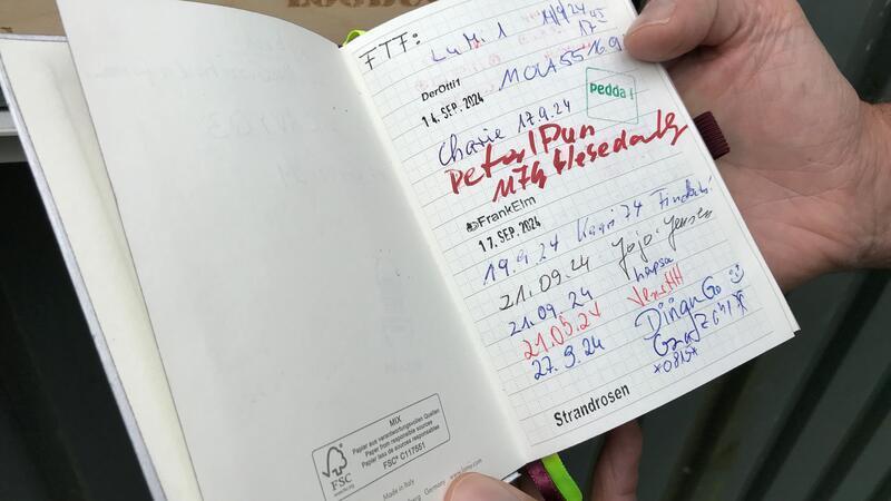 Geocaching feiert Geburtstag: Die ewige Suche nach dem perfekten Versteck Geocacher tragen sich in ein Logbuch ein.