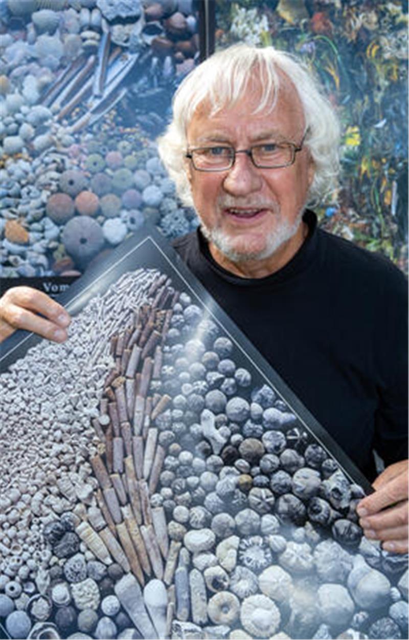 Schätze auf Rügen – Was finden Sammler an der Ostseeküste? Geologe Rolf Reinicke, zeigt ein Plakat mit Funden der Kreideküste.