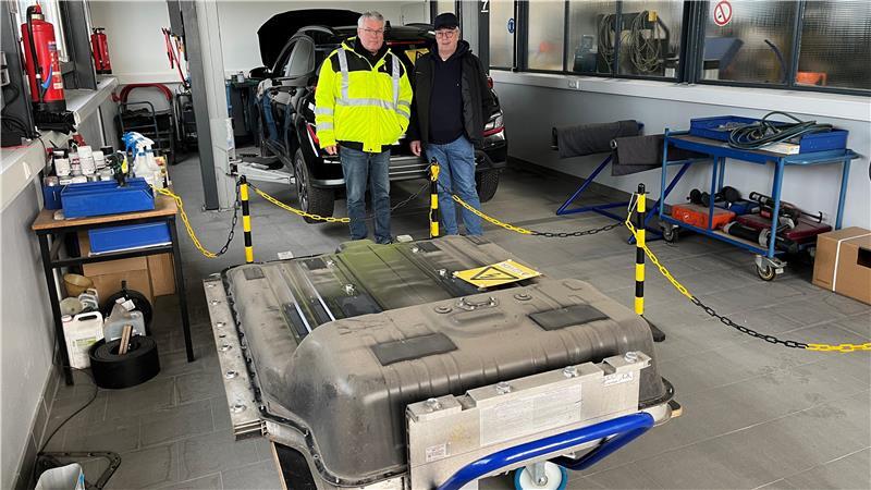 Gerd Bröhan blickt mit Bürgermeister Matthias Riel auf einen Auto-Akku.