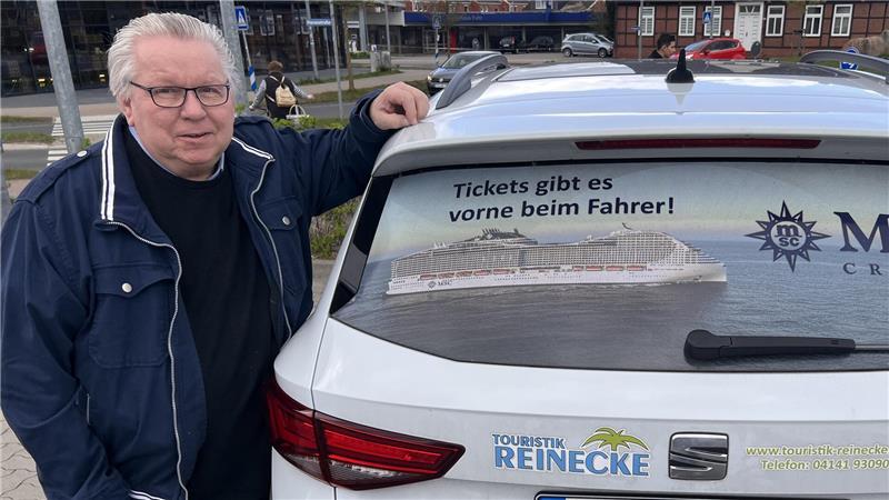 Gern zu Scherzen aufgelegt: Wolfgang Reinecke vor seinem Dienstauto. Tickets für Kreuzfahrten gibt es „vorne beim Fahrer“.