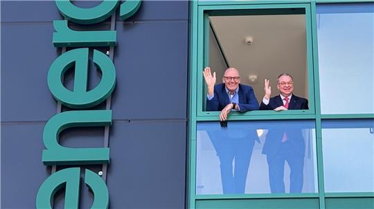 Geschäftsführer Jens Saß (links) und Gesellschafter Nicolas Mohr winken aus dem Neubau des Medizintechnik-Unternehmens Implantcast. 