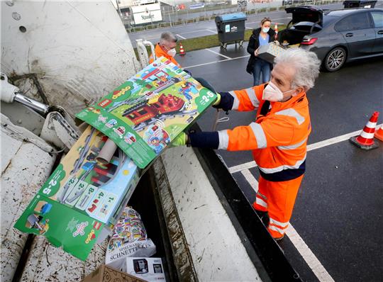 Geschenkpapier und -Kartons wirft ein Mitarbeiter der Entsorgungsbetriebe in einen Müllwagen (Symbolbild). Foto: Roland Weihrauch/dpa