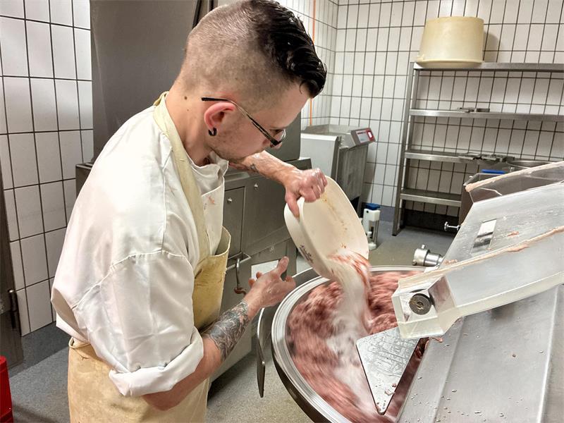 Geselle Elias bereitet die Rohmasse für den Leberkäse vor.