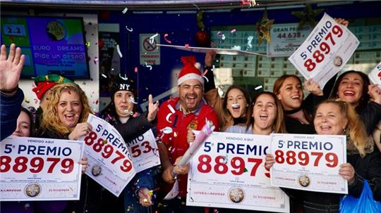 Gewinner der Weihnachtslotteriepreise feiern vor einer Lottoannahmestelle in Málaga.