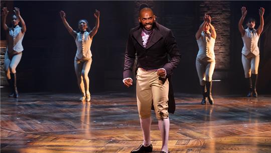 Gino Emnes als Aaron Burr und mehrere Tänzer zeigen Szenen des Musicals „Hamilton“ im Operettenhaus Hamburg. Foto: Ulrich Perrey/dpa