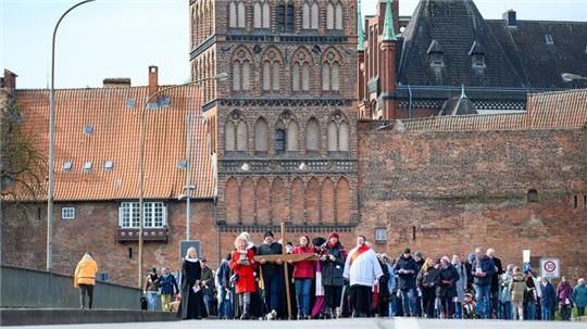 Gläubige tragen das Holzkreuz über die Burgtorbrücke.