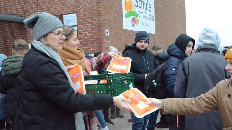 Gleichstellungsbeauftragte Andrea Jülisch und Stellvertreterin Stefanie Nitschke (von links) verteilen Tüten an die Schüler.