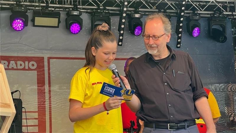 Gewinner der 6. Lions Club Charity stehen fest Glücksfee Finja Dölitsch von der DLRG und Frank Münter, stellvertretender Vorsitzender des Lions Club Stade, verkündeten die Losnummer des ersten Preises. Foto: Bisping