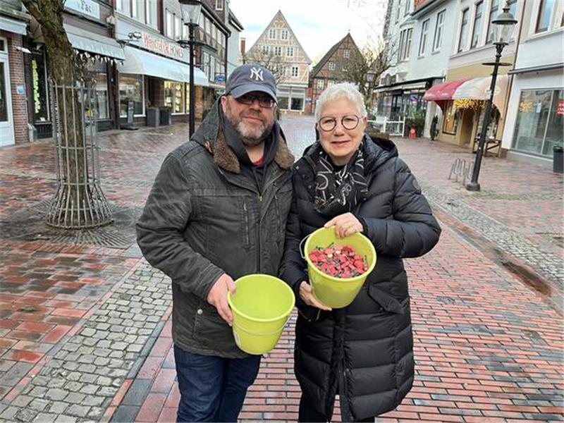 Glücksschweineverkauf in der Breiten Straße in Buxtehude: Die stellvertretende Bürgermeisterin Petra Möhle und der Erste Stadtrat Ralf Dessel sind ein eingespieltes Team. Foto: Wisser