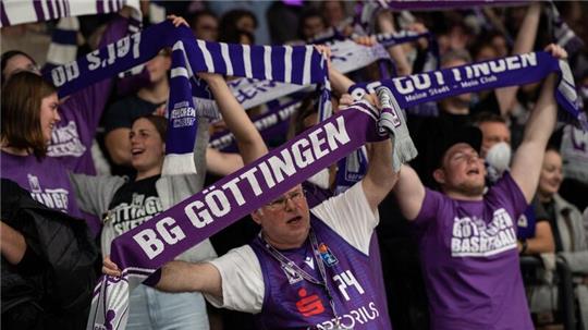 Göttinger Fans stehen mit ihren Schals auf der Tribüne und feiern.